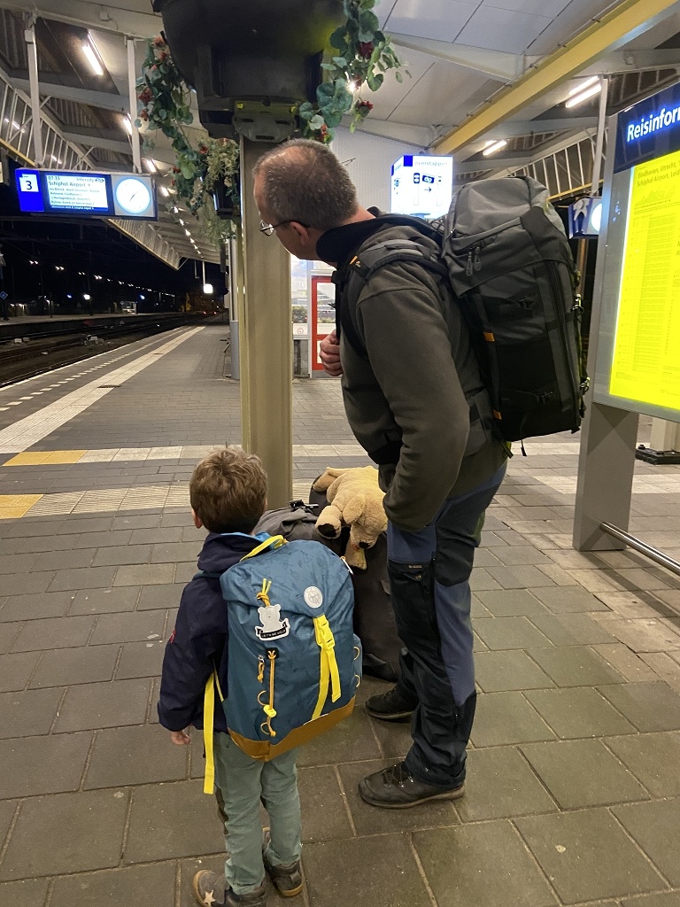 Ein Mann und ein Kind stehen am Bahnhof