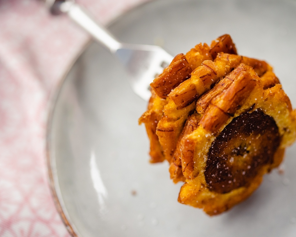 Patacones auf einer Gabel, frittierte Kochbananen